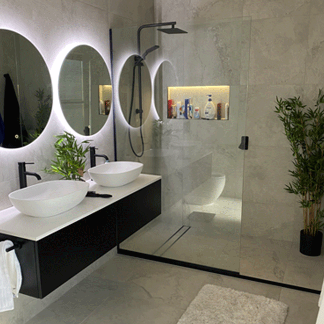 Bathroom with backlit mirrors